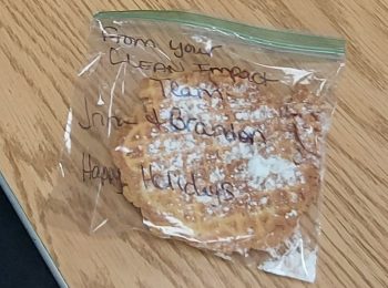 Homemade cookie in a bag with handwritten note from Clean Impact LLC team, expressing kindness and appreciation.